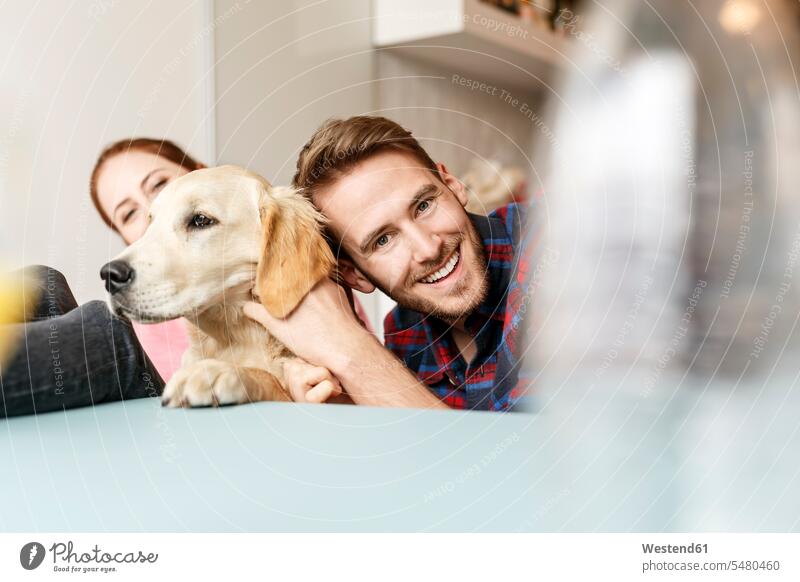 Happy young couple with dog at home dogs Canine happiness happy playing twosomes partnership couples pets animal creatures animals people persons human being