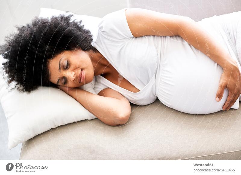 Pregnant woman relaxing on couch lying laying down lie lying down pregnant Pregnant Woman females women Adults grown-ups grownups adult people persons