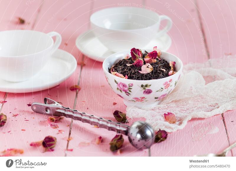 Bowl of black tea with dried rose blossoms nobody Tea Cup Tea Cups Teacup Teacups tea strainer Tea Strainers scattered fabric fabrics cloth Black Tea