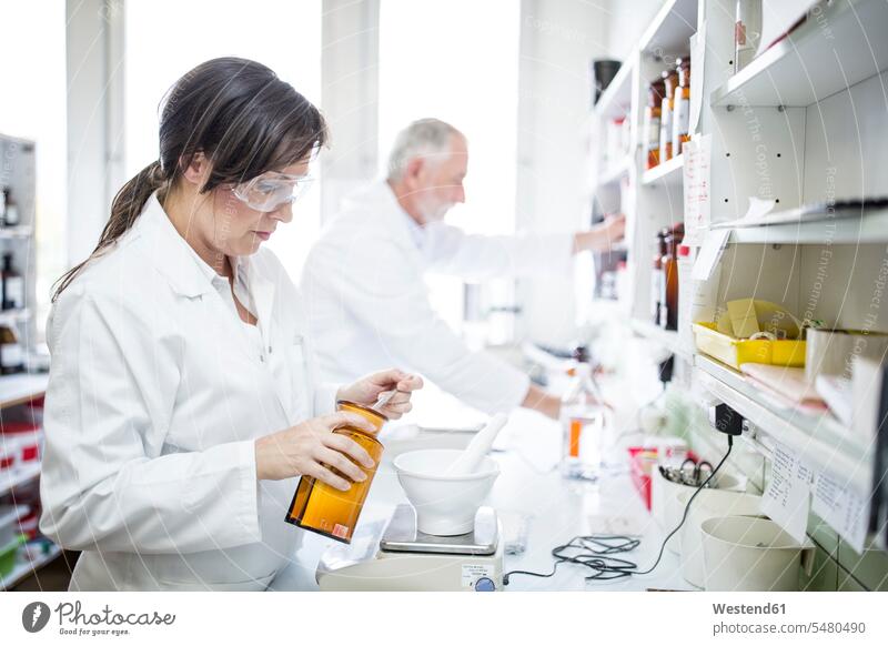 Man and woman working in laboratory of a pharmacy Apothecary drugstores pharmacies At Work females women healthcare and medicine medical