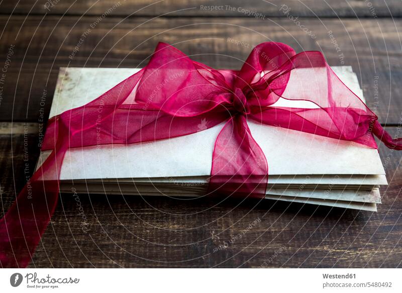 Stack of old love letters tied with red ribbon remembrance remember romantic lyrical Romance symbolical picture Symbolism love-letter love-letters indoors