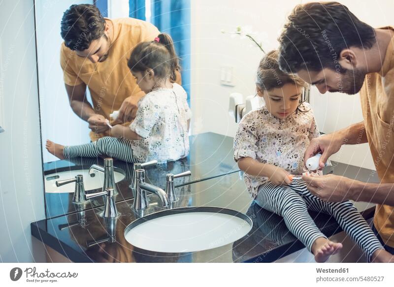 Father and daughter in bathroom brushing teeth toothbrush tooth-brushes toothbrushes cleaning cleanse cleansing Bath Toothpaste Dentifrice daughters father