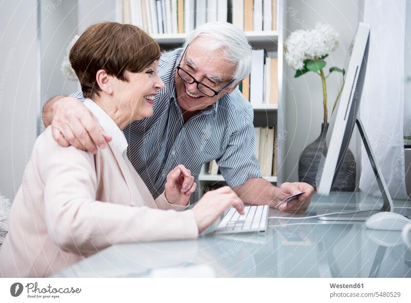 Senior couple shopping online with credit card debit card relationship Human Relationship consumerism confidence confident togetherness age toothy smile