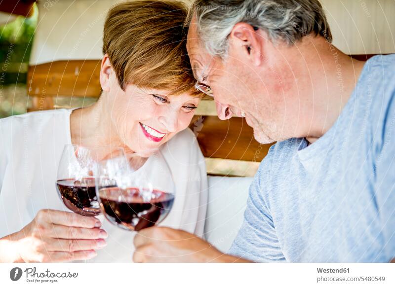 Happy senior couple having glass of red wine happiness happy twosomes partnership couples smiling smile Wine people persons human being humans human beings