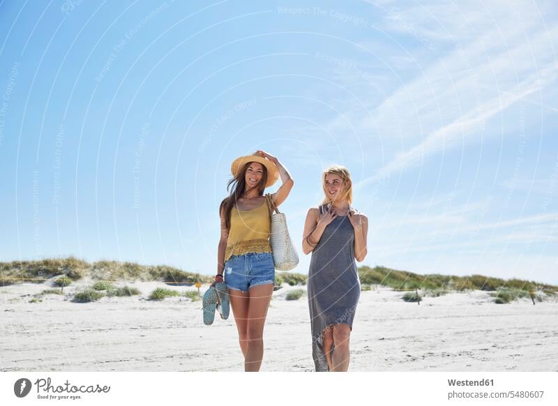 Two female friends on the beach smiling smile woman females women vacation Holidays beaches mate friendship Adults grown-ups grownups adult people persons