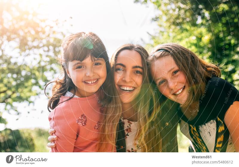 Portrait of three happy girls outdoors sister sisters females happiness smiling smile portrait portraits siblings brother and sister brothers and sisters family
