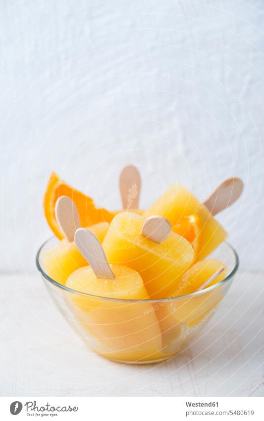 Glass bowl of homemade orange popsicles Bowl Bowls frozen on top of sweet Sugary sweets fruit home made home-made fruity orange slice orange slices sorbet