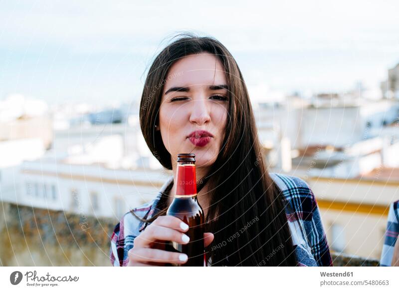 Spain, Jerez de la Frontera, portrait of winking young woman with beer bottle pouting mouth caucasian caucasian ethnicity caucasian appearance european relaxed