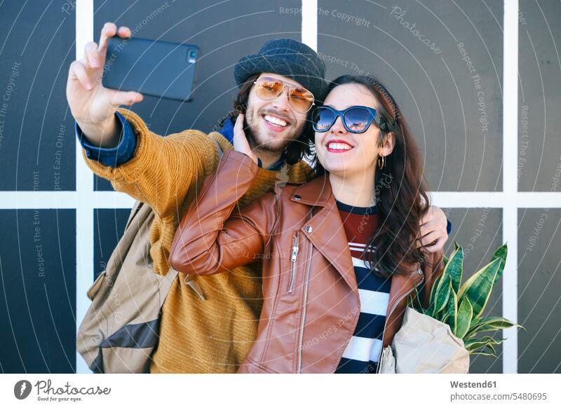 Happy young couple taking selfie with smartphone Selfie Selfies twosomes partnership couples Smartphone iPhone Smartphones people persons human being humans