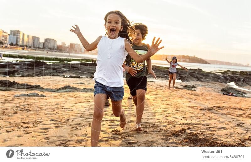 Kids running on the beach at sunset playing friends beaches girl females girls friendship child children kid kids people persons human being humans human beings