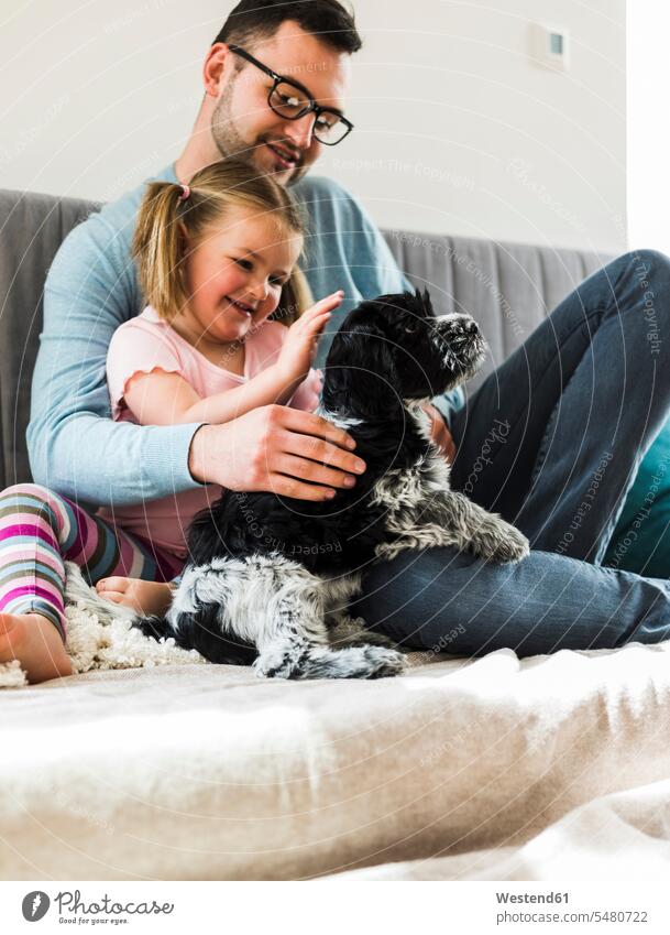 Father and daughter petting dog at home smiling smile daughters father pa fathers daddy dads papa child children family families people persons human being