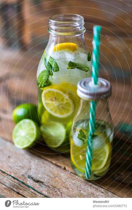 Glass bottles of infused water with lemon, lime, mint leaves and ice cubes Leaf Leaves Lime Lime Fruit Lime Fruits Limes healthy ready to eat ready-to-eat