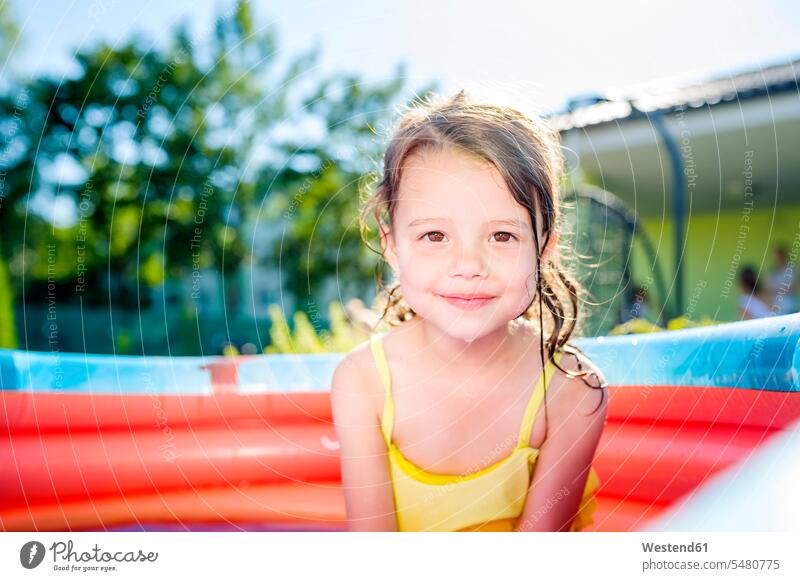 Portrait of smiling little girl sitting in paddling pool females girls Paddling pool Paddling pools inflatable pool portrait portraits splashing smile child