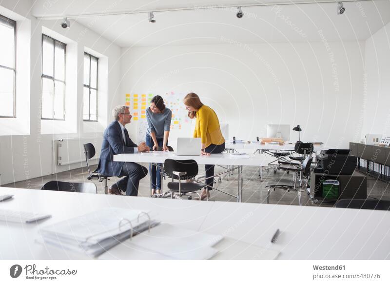 Businessman and two women in office having a meeting Munich Conference Table discussing discussion Business Meeting business conference Female Colleague