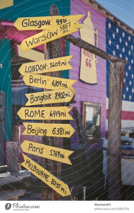 USA, Arizona, Seligman, signpost with capital cities at Route 66 distance western script journey travelling Journeys voyage medium group of objects writing