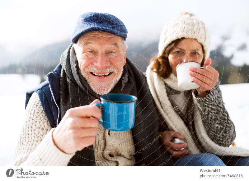Portrait of senior man with hot beverage in winter senior men elder man elder men senior citizen portrait portraits snow senior adults males Adults grown-ups