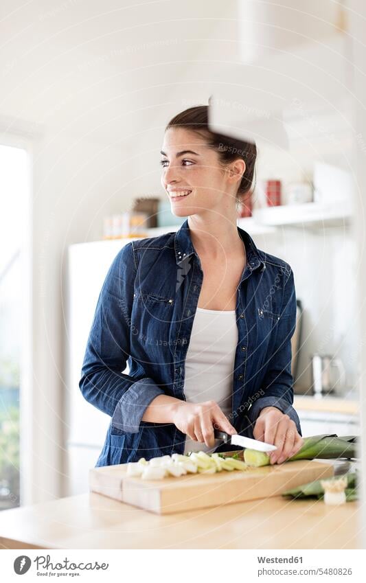 Young woman in kitchen preparing food smiling smile domestic kitchen kitchens females women Food Preparation Adults grown-ups grownups adult people persons