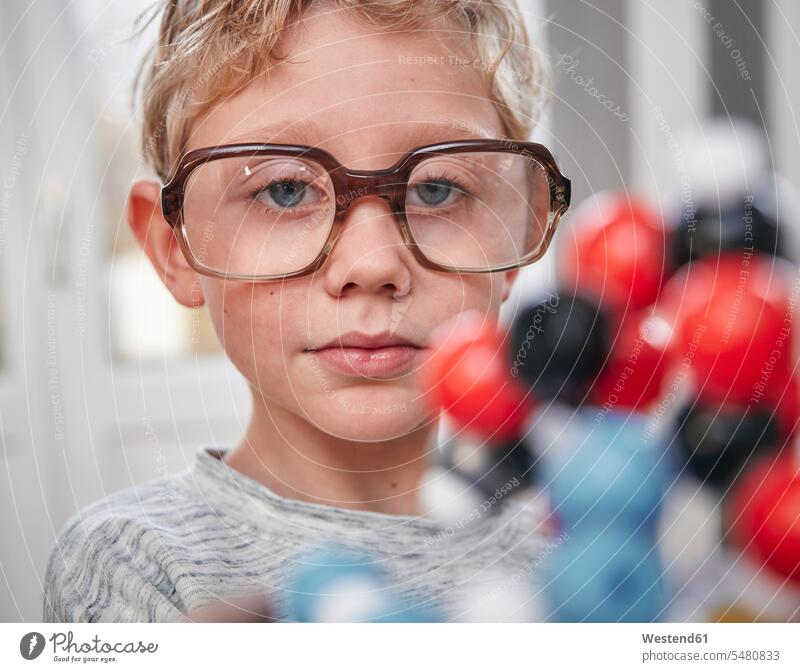 Boy wearing oversized glasses looking at molecular model boy boys males models portrait portraits specs Eye Glasses spectacles Eyeglasses child children kid