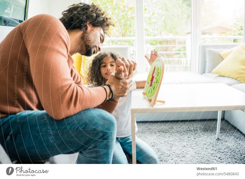 Father helping daughter learn reading the clock assistance assisting Help daughters time father pa fathers daddy dads papa learning Clock Clocks homework