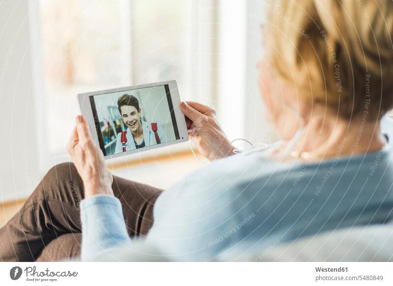 Senior woman looking at picture of young man on digital tablet smiling smile convenience amenities convenient amenity comfort Connection connected Connections
