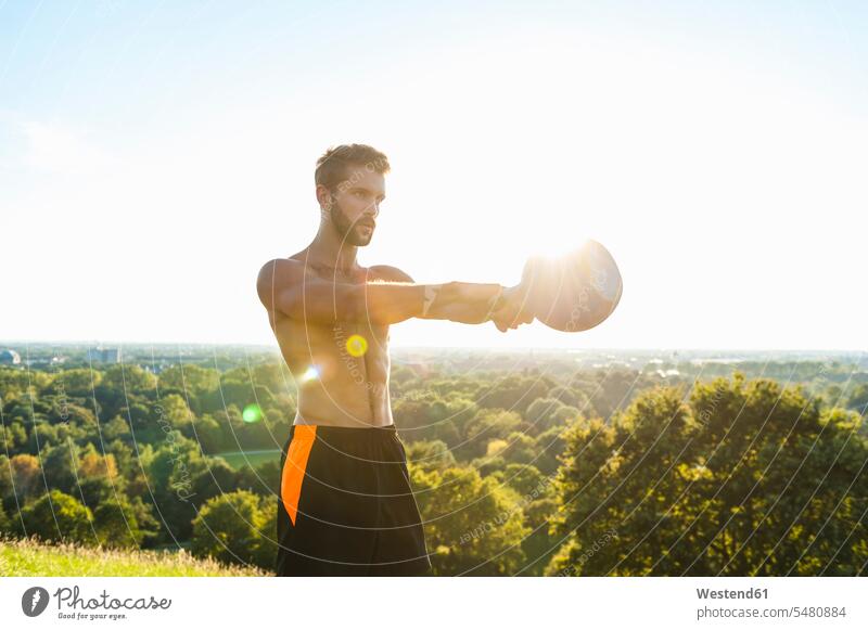Man exercising with kettlebell outdoors Kettlebell Kettle bells Kettlebells athlete Sportspeople Sportsman Sportsperson athletes Sportsmen males exercise