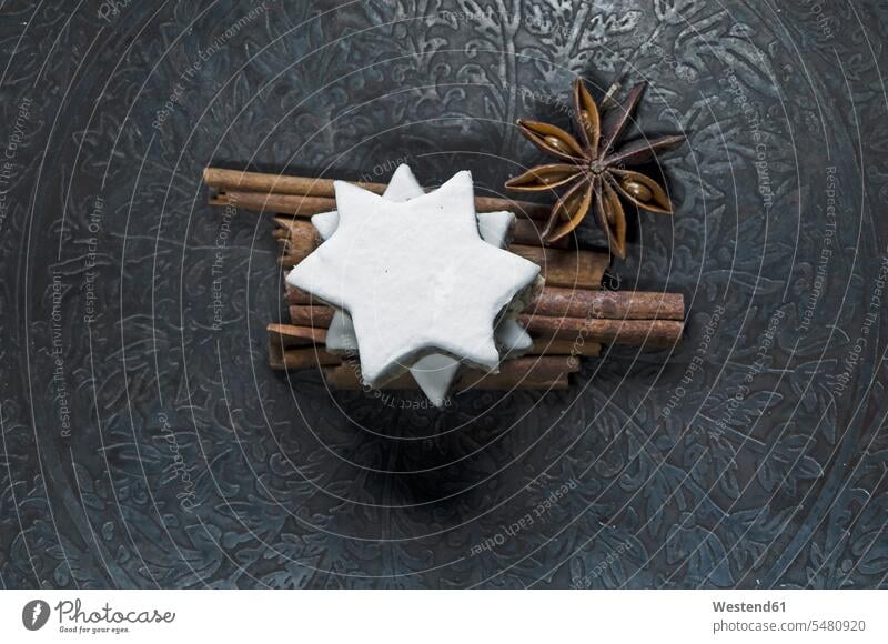 Cinnamon stars, cinnamon sticks and star anise on metal plate Christmas Cookie Christmas Cookies Christmas Biscuits icing sugar icing frosting still life