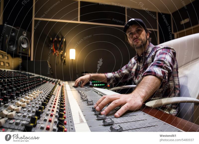 Man working in the control room of a recording studio Recording Studio audio engineer audio technician sound engineer sound technician Mixing Console mixer