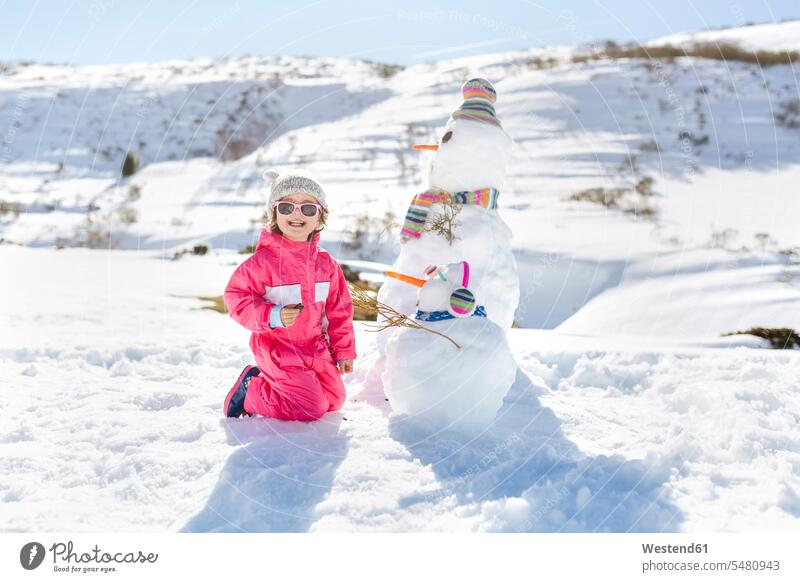 Girl playing with snowmen in winter holidays childhood leisure free time leisure time smiling smile snowman Enjoyment Amusement pleasure enjoy enjoying