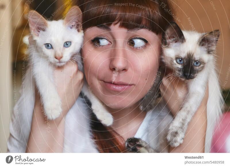 Funny portrait of young woman holding two kittens females women portraits cat cats Adults grown-ups grownups adult people persons human being humans