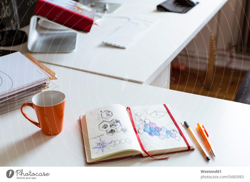 Notebook with sketch and cup of coffee on desk in office drawing drawings Coffee Cup Coffee Cups notebook notebooks offices office room office rooms Table