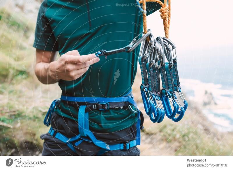 Young man preparing climbing equipment males Preparation prepare rope ropes carabiner Carabiners snap hook Adults grown-ups grownups adult people persons