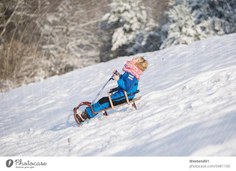 Girl tobogganing downhill caucasian caucasian ethnicity caucasian appearance european sledge sledges Skiwear ski suits Ski-Wear Ski Wear warm clothing