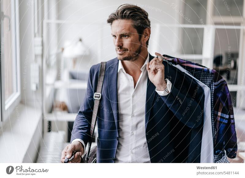 Serious businessman carrying clothes Businessman Business man Businessmen Business men window windows business people businesspeople business world