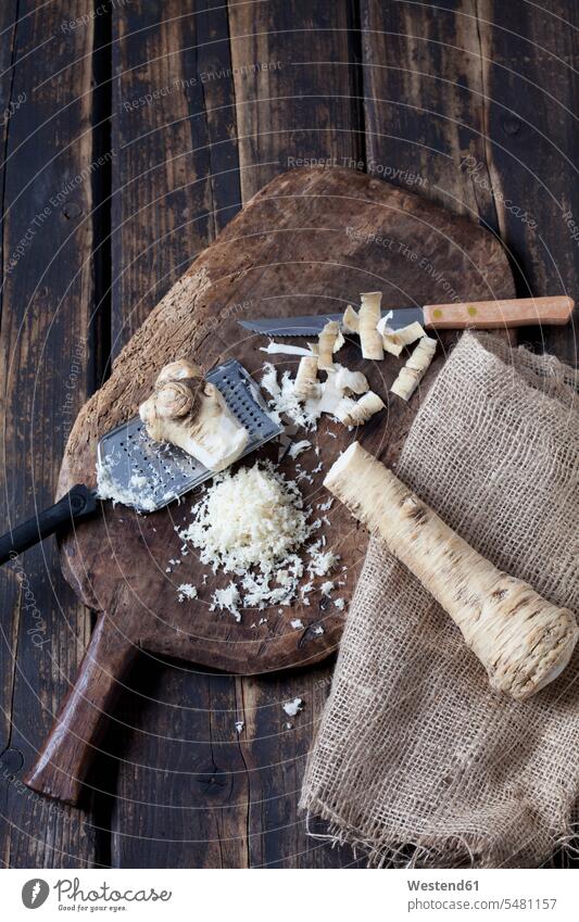Peeled and grated horseradish on wooden board dark peeled shell shells peels wooden boards wooden panel wooden panels grater graters hot spicy cut Kitchen Knife