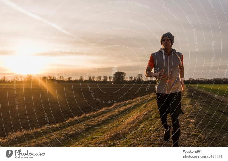 Man running in rural landscape at sunset man men males Jogging Adults grown-ups grownups adult people persons human being humans human beings fitness sport