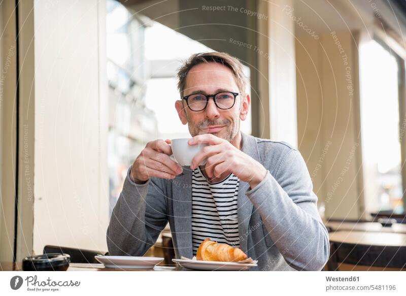 Portrait of smiling mature man drinking coffee in a sidewalk cafe men males sidewalk cafes pavement cafes Adults grown-ups grownups adult people persons