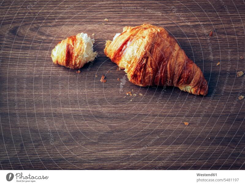 Croissant on dark wood French Food French Cuisine overhead view from above top view Overhead Overhead Shot View From Above nobody copy space wooden crumbs tasty