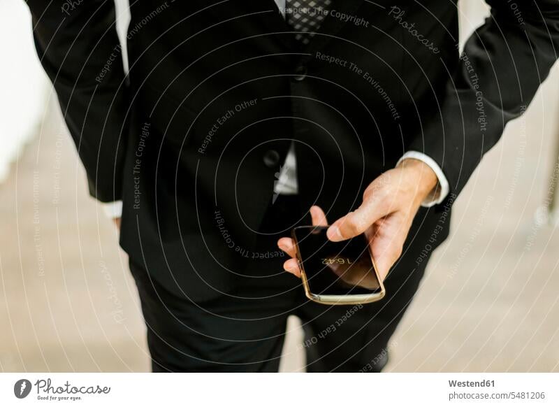 Close-up of businessman using smartphone outdoors use mobile phone mobiles mobile phones Cellphone cell phone cell phones Businessman Business man Businessmen