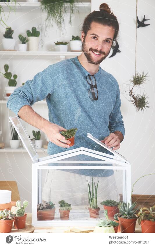 Man putting cacti and succulents in a small greenhouse Plant Plants Cactus Cactaceae Cacti Cactuses smiling smile potted plant potted plants pot  plants