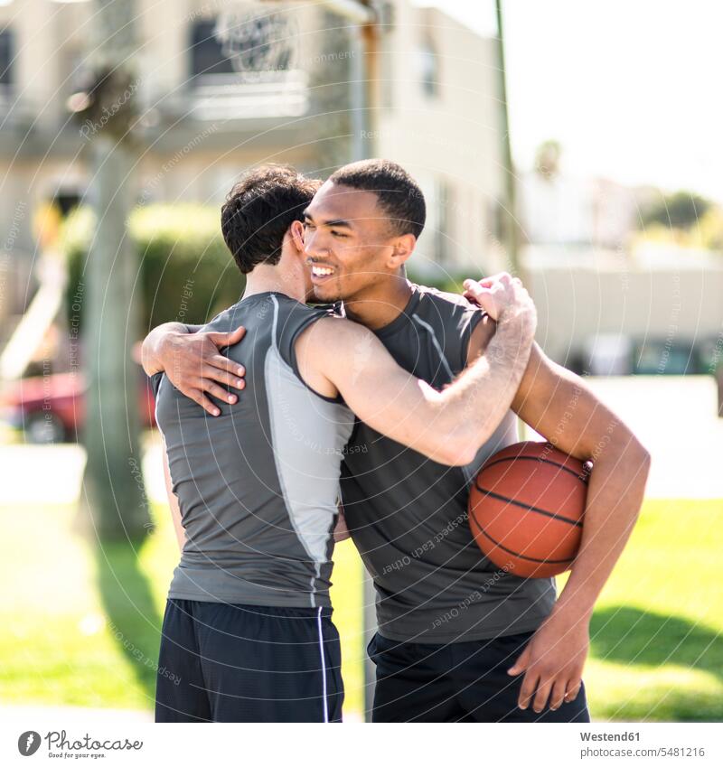 Two basketball players embracing outdoors African-American Ethnicity Afro-American African American Ethnicity African Americans Afro-Americans fit multicultural