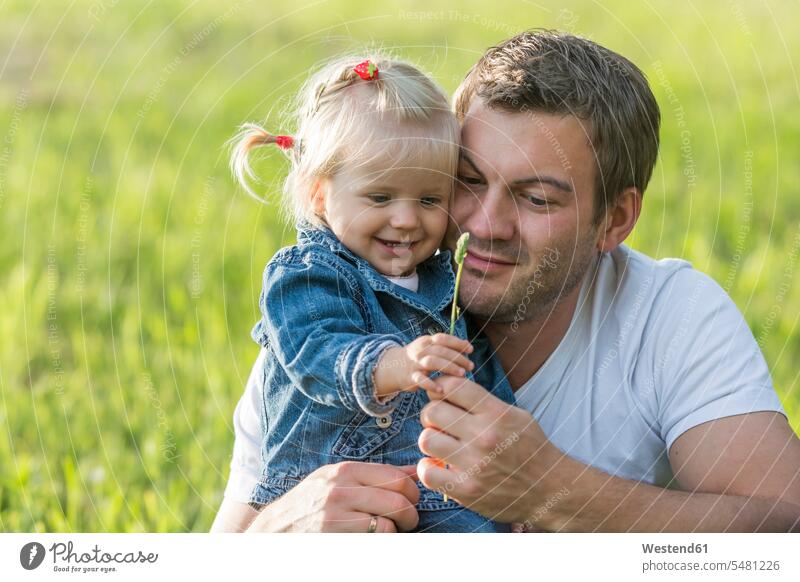 Father with little daughter on a meadow cute twee Cutie holding Twig Twigs sprig sprigs nature natural world Joy enjoyment pleasure Pleasant delight bonding