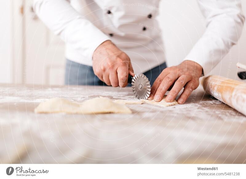 Chef cutting fresh ravioli chef cook cooks Chefs cooking Ravioli midsection mid section copy space Flour Flours Selective focus Differential Focus Freshness