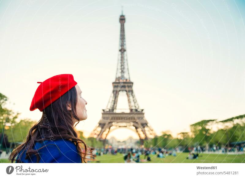 France, Paris, Champ de Mars, woman wearing red beret in front of Eiffel Tower looking up females women tower towers built structure buildings built structures