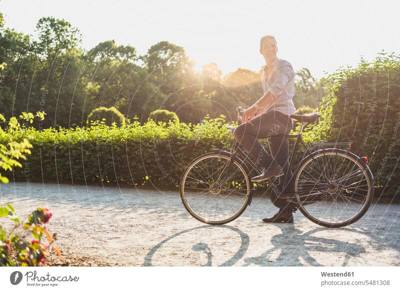 Man with bicycle in a park at sunrise man men males bikes bicycles parks Adults grown-ups grownups adult people persons human being humans human beings