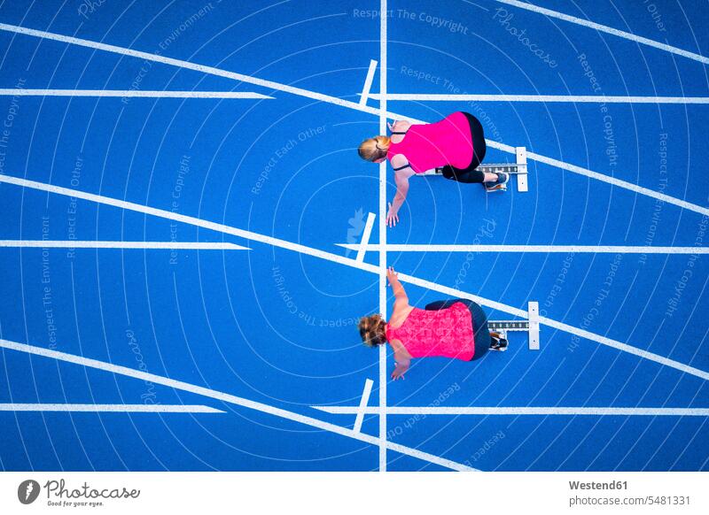 Top view of two female runners starting on tartan track overhead view from above top view Overhead Overhead Shot View From Above racetrack race course