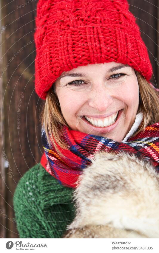 Portrait of happy woman wearing red bobble hat in winter hibernal portrait portraits females women Adults grown-ups grownups adult people persons human being