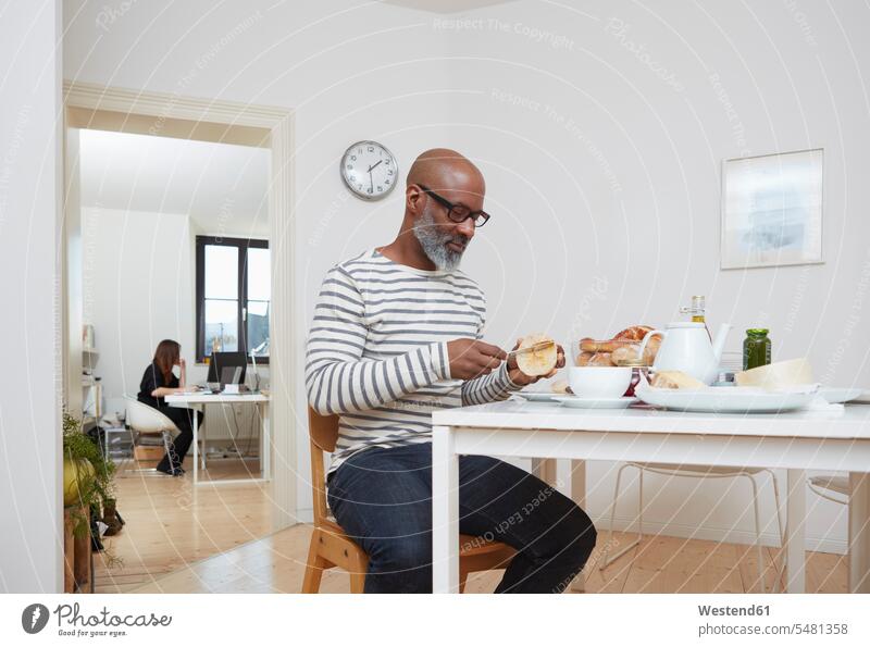 Man having late breakfast at his home office African-American Ethnicity Afro-American African American Ethnicity African Americans Afro-Americans bald baldy