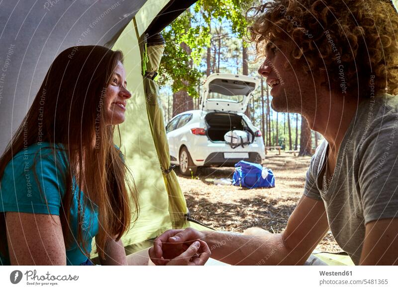 Smiling young couple in a tent smiling smile twosomes partnership couples tents people persons human being humans human beings recovering positive individuality