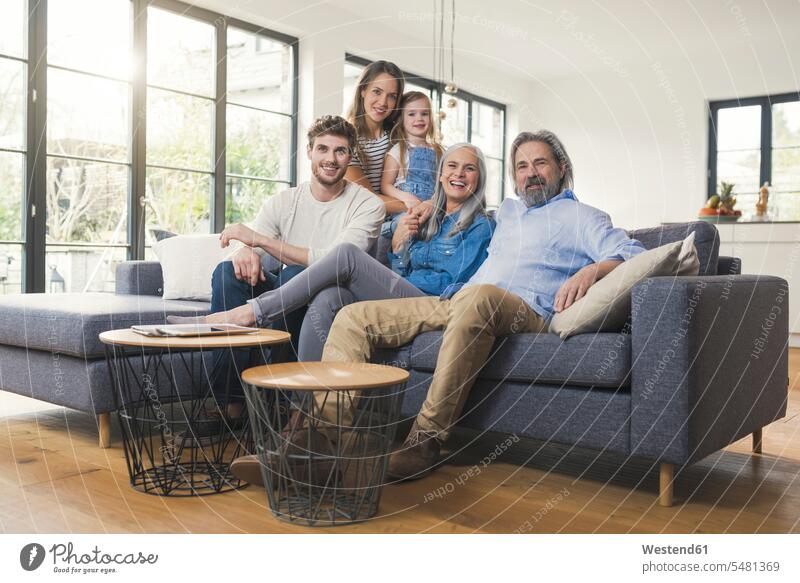 Extended family sitting on couch, smiling happily happiness happy settee sofa sofas couches settees home at home Seated together cozy sociable comfortable cosy