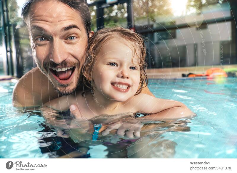 Portrait of happy father with daughter in indoor swimming pool swimming bath portrait portraits daughters happiness indoor swimming pools pa fathers daddy dads